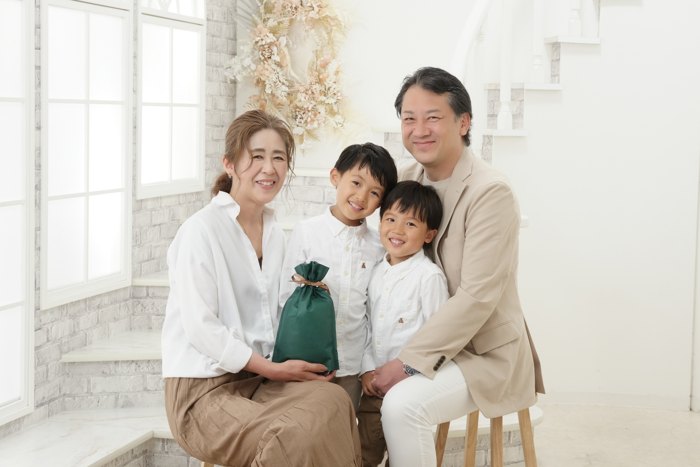 ギフトを抱えたおばあちゃんとお孫さんたちの記念写真